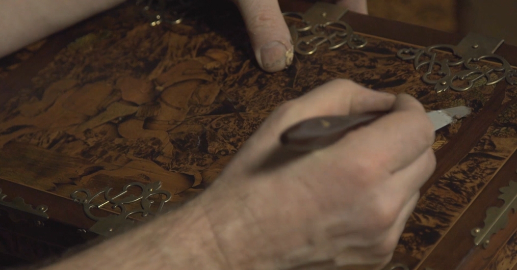 Film "Sztuka konserwacji – konserwacja sztuki" - kadr z ręką trzymającą szpachlę malarską